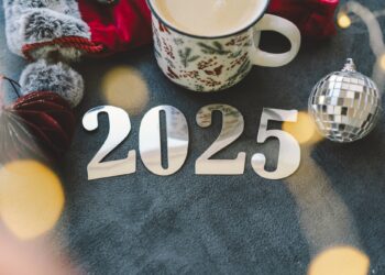 Cozy winter setup with a warm drink, festive decorations, and New Year’s numbers.