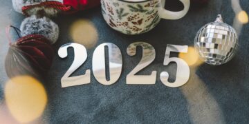 Cozy winter setup with a warm drink, festive decorations, and New Year’s numbers.